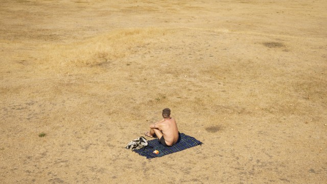 Article thumbnail: A man sunbathes in a nearly empty Greenwich Park, London, as a drought has been declared for parts of England following the driest summer for 50 years. Picture date: Sunday August 14, 2022. PA Photo. A four-day amber warning for extreme heat from the Met Office is in place for much of England and Wales until Sunday, with warnings of health impacts and disruption to travel. Photo credit should read: Dominic Lipinski/PA Wire