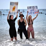 Article thumbnail: Surfers Against Sewage activists hold placards during a protest against sewage pollution in Brighton, southern England, on May 20, 2023. England's privatised water companies pledged this week to make massive investments to stop raw sewage being pumped into waterways as concerns mount about water quality and laxer environmental protections post-Brexit. (Photo by Ben Stansall / AFP) (Photo by BEN STANSALL/AFP via Getty Images)