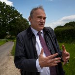 Article thumbnail: Ed Cavey, leader of the Liberal Democrats meets activists and the local candidate Paul Fellows, on a visit to the site of a proposed Gas and oil drill site in Dunsfold, Surrey. 25/5/23. Photo Tom Pilston