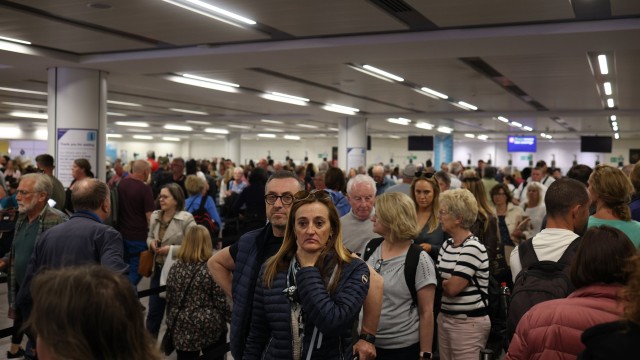 Article thumbnail: CRAWLEY, ENGLAND - MAY 27: Passengers queue at Gatwick Airport as electronic passport gates fail across the UK on May 27, 2023 in Crawley, England. Passengers arriving at airports in the UK are facing delays to their bank holiday weekend after a national system failure. (Photo by Dan Kitwood/Getty Images)
