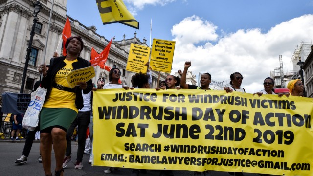 Article thumbnail: Justice for Windrush protesters hold a Windrush Day of Action, marching from Downing Street to hang a banner from Westminster Bridge. (Photo credit should read Matthew Chattle/Future Publishing via Getty Images)