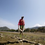 Article thumbnail: FILE PHOTO: Fisherman Gabriel Barreto walks on the shore of the Magdalena river, the longest and most important river in Colombia, in the city of Honda, January 14, 2016. While flooding and intense rain wreak havoc on several countries in Latin America, El Nino brings other harmful effects to Colombia with severe drought. Picture taken January 14, 2016. REUTERS/John Vizcaino/File Photo